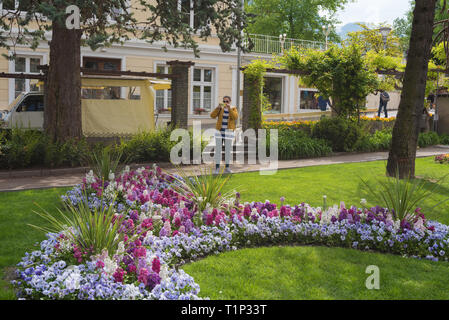 Jardin à Meran (Merano), Italie - un touriste avec l'appareil photo pour tirer sur les fleurs, Trentin-Haut-Adige, Italie du nord Banque D'Images