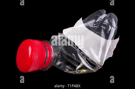 Bouteille de plastique utilisé. Bonnet Rouge. White label. Isolées. Fond noir. Une boisson en PET transparent vide rétractable. Le tri des déchets, le recyclage, l'élimination. Banque D'Images