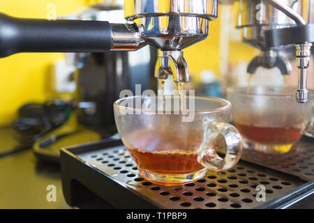 Machine à thé la préparation du thé chaud et verser dans des tasses dans le café. Banque D'Images