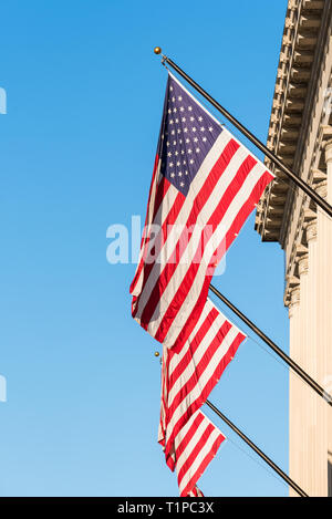 Les drapeaux nationaux des États-Unis d'Amérique qui tournent à l'extérieur du bâtiment du Département du Commerce des États-Unis à Washington DC Banque D'Images