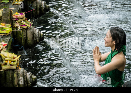 Bali, Indonésie - le 22 janvier 2019 : femme priant au printemps de l'eau sainte Pura temple Tirta Empul à Tampa, Bali, Indonésie. Banque D'Images