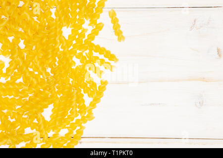 Beaucoup de morceaux de italitan flatlay torti pâtes jaune sur bois blanc Banque D'Images