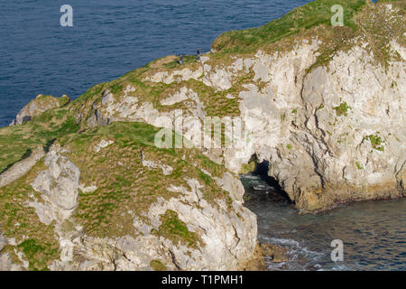 Vue aérienne de Kinbane Head sur la côte nord du comté d'Antrim, en Irlande du Nord, avec des gens sur un étroit chemin de falaise. Banque D'Images