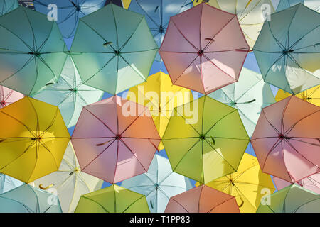 Parasols colorés décoratifs accroché dans le passage libre avec ciel bleu clair Banque D'Images