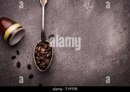 Les grains de café et thé en cuillères plus rustique en pierre sombre contexte Banque D'Images