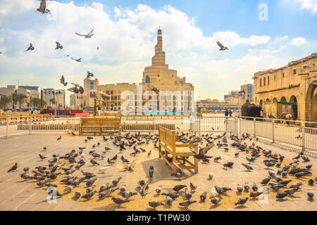 Doha, Qatar - 20 Février 2019 : de nombreux pigeons voler dans Souq Waqif square. Moyen-orient, Péninsule Arabique, du golfe Persique. Fanar Centre culturel islamique Banque D'Images