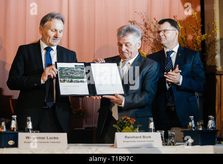 28 mars 2019, Saxe, Trebendorf : Waldemar Locke, (l) Maire de Trebendorf, et Reinhard Bork, Maire de Schleife (M), ont signé un contrat pour la réinstallation du village dans le "Gasthaus Zur Erholung' dans Mühlrose en Lusace. Le contrat pour la réinstallation du village entre les municipalités de Trebendorf et Schleife et la compagnie d'énergie Leag a été signé. Mühlrose est un des derniers villages du district de Lusace pour céder la place à charbon brun, qui est d'être dragué au début de l'années 2030. Lausitz Energie Bergbau AG prévoit un volume de production de 150 millions de tonnes Banque D'Images