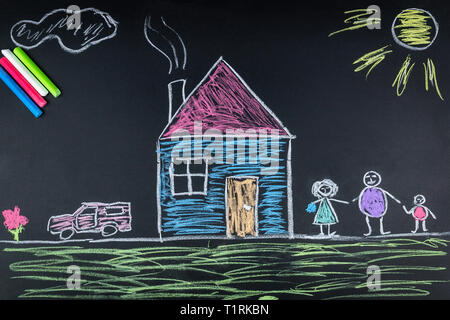 Enfant dessine une famille une maison et une voiture sur le conseil scolaire Banque D'Images