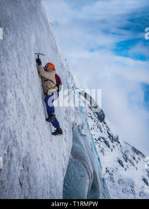 Homme grimpant sur une falaise ou un glacier en Islande Banque D'Images