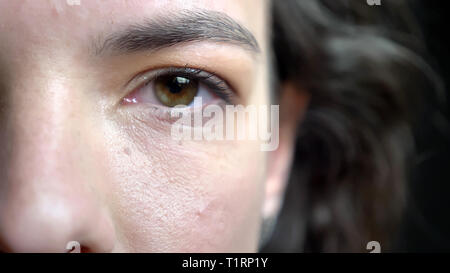 Demi-gros plan face à de jeunes pousses pretty caucasian visage féminin avec brunette cheveux bouclés et des yeux marron à la caméra à droite Banque D'Images