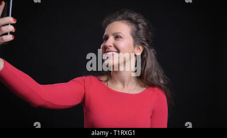 Closeup portrait of attractive middle-aged woman en tenant vos autoportraits sur le téléphone et en souriant avant de l'appareil photo Banque D'Images