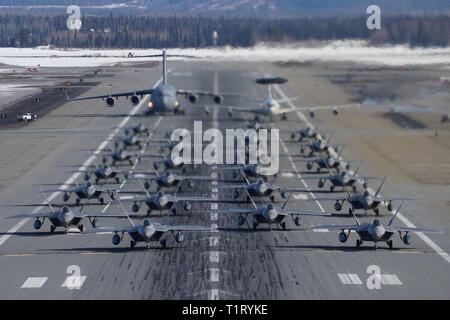 F-22 Raptors à partir de la 3e Escadre et 477th Fighter Group participent à une formation serrée avec un taxi E-3 Sentry et un C-17 Globemaster III, connu comme un éléphant à pied, le 26 mars 2019, au cours d'un exercice de la Force polaire at Joint Base Elmendorf-Richardson, en Alaska. Cet exercice de deux semaines d'escadrons donne l'occasion de démontrer leurs capacités à l'avant de déployer et de livrer combat écrasante. (U.S. Air Force Photo de Justin Connaher) Banque D'Images