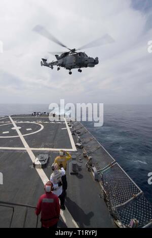 190323-N-QR145-126 MER MÉDITERRANÉE (23 mars 2019) - Maître de Manœuvre 3 classe Jake Ellingson salue une Marine royale britannique hélicoptère AW159 Wildcat, affecté à la défense aérienne audacieuse-class destroyer HMS Duncan (D 37), pendant les opérations de vol à bord de la classe Arleigh Burke destroyer lance-missiles USS Ross (DDG 71) dans la mer Méditerranée, le 23 mars 2019. Ross est actuellement intégrée dans le commandant de la Force 473 à : britanniques, danois, français, et l'armée américaine dirigée par Marine nationale porte-avions Charles de Gaulle (R 91). (U.S. Photo par marine Spécialiste de la communication de masse 2e classe Krysti Banque D'Images