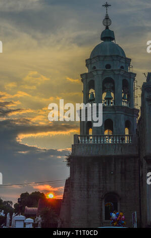 Un coucher de ciel derrière un tour de l'église. Banque D'Images