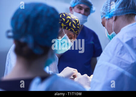 Chirurgiens sérieux durant une opération chirurgicale à l'hôpital. Traitement croisé Banque D'Images