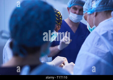 Chirurgiens sérieux durant une opération chirurgicale à l'hôpital. Traitement croisé Banque D'Images