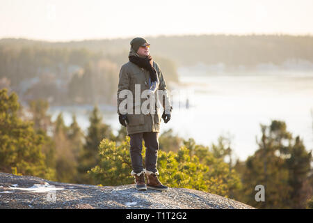 La Finlande, Helsinki, la fin de l'automne. Mer Baltique, bay. Encore de l'eau du golfe, des îles avec les forêts. Soleil d'hiver faible, crépuscule, pins sur rock. Banque D'Images