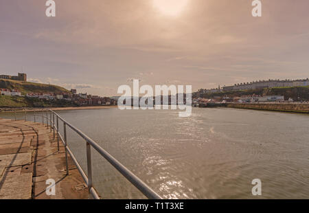 Whitby Harbour Town et à l'intérieur. Les bâtiments de la ville vers le haut de la pile à côté de la voie d'eau et de la plage de sable conduit à bord de l'eau. Une cl Banque D'Images