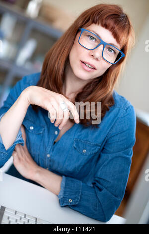 femme moderne aux cheveux rouges avec lunettes Banque D'Images