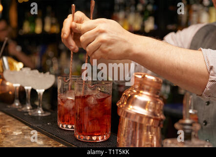 Barman est en remuant des cocktails sur comptoir bar Banque D'Images