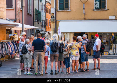 Le lac de Garde, ITALIE - Septembre 2018 : Tour guide expliquant l'histoire locale à un groupe de touristes dans la ville de Garda, sur le lac de Garde. Banque D'Images