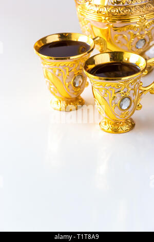 Still Life with golden traditionnel café arabe avec dallah et de la cuvette. Arrière-plan blanc. Ramadan concept. Banque D'Images