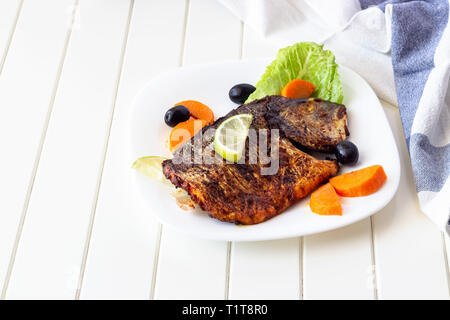 Grillades de poissons dorade aux légumes sur plaque blanche. Arrière-plan blanc. Alimentation saine food concept. Banque D'Images