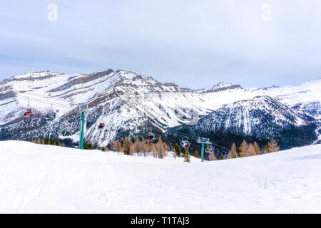 Les skieurs et planchistes non identifiables sur télésiège remontant une pente de ski dans la montagne enneigée (éventail des Rocheuses canadiennes au Lac Louise, près de Banff Banque D'Images