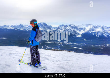 Jeune skieur debout au bord d'une chaîne de montagnes dans le lac Louise au les Rocheuses canadiennes de l'Alberta, Canada. Banque D'Images
