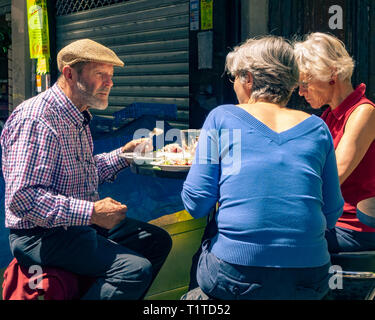 Homme et deux femmes en train de déjeuner dans la zone du marché de Ternes, Paris France Banque D'Images
