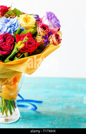 Bouquet de roses multicolores sur table en bois Banque D'Images