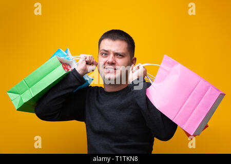 Photo d'un homme avec des sacs de différentes couleurs. Banque D'Images