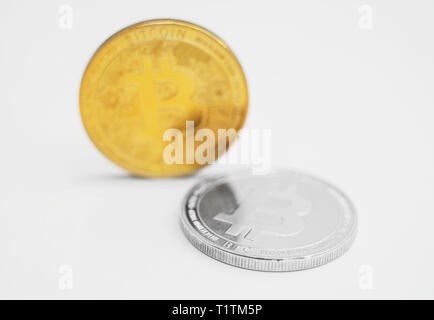 Version physique d'argent et d'or des bitcoins sur fond blanc. Banque D'Images