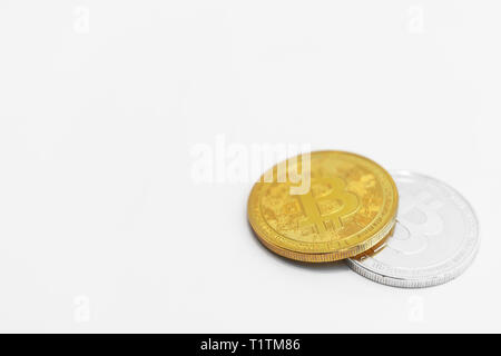 Version physique d'argent et d'or des bitcoins sur fond blanc. Banque D'Images