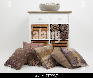 Une commode en bois, coussins, plaids, sur un fond blanc Banque D'Images