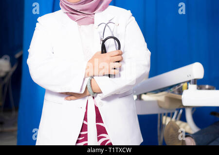 Le Hijab musulman female dentist holding stethoscope en face de dentiste dans sa propre clinique président Banque D'Images