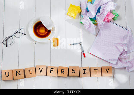 La papeterie et l'Université fait de lettres de mots sur fond de table en bois. L'éducation, collège, école, stress, étudiant le concept. Télévision laïcs ou Vue de dessus Banque D'Images