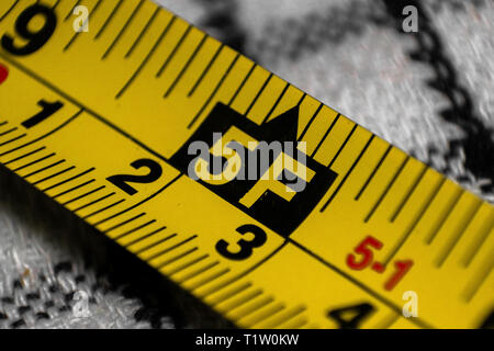 Ruban jaune montrant en mètres et en pieds de mesure Banque D'Images