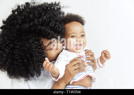 Closeup portrait of beautiful african woman holding sur les mains sa petite fille sur fond blanc. La famille, l'amour, de vie, de la maternité et des moments tendres concepts. Concept de la fête des mères ou d'arrière-plan Banque D'Images