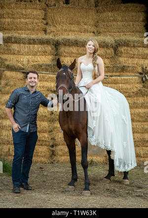 Bride and Groom posing with horse , une grange Banque D'Images