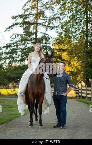 Bride and Groom posant dehors avec cheval arabe Banque D'Images