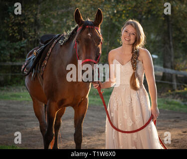 Les jeunes à bride sa grange avec son cheval arabe Banque D'Images