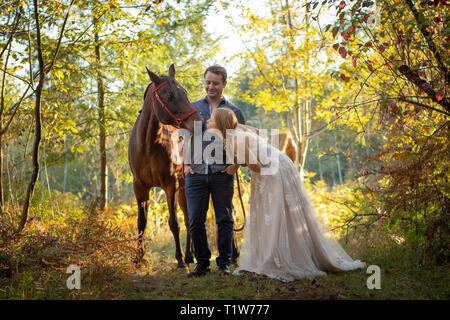 Bride son cheval donnant un baiser avec le marié à la sur Banque D'Images