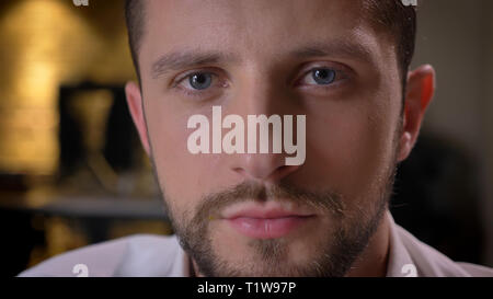 Avant de tirer Gros plan portrait adultes hommes barbus avec les yeux face à la caméra à l'intérieur avec intérieur sur l'arrière-plan Banque D'Images