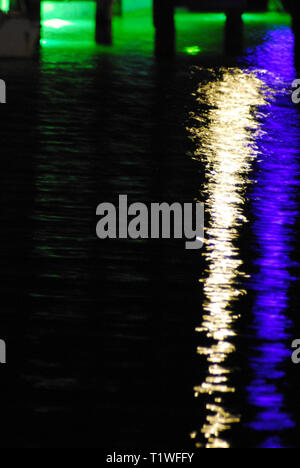 Les lumières vives des bateaux pris en compte sous un dock sur une nuit sombre. Photographié à Noosa, Australie Banque D'Images