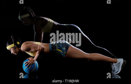 Un mixed race woman exercice exercices de fitness isolé sur fond noir avec effet lightpainting expositions multiples Banque D'Images