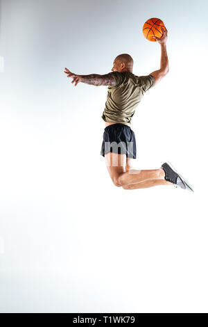 Man jumping haut avec un ballon de basket-ball dans sa main Banque D'Images