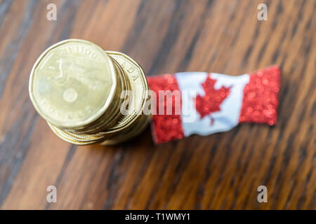 Pile de pièces de un dollar canadien avec drapeau canadien Banque D'Images