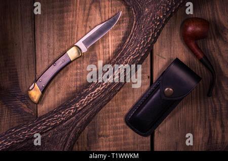 Couteau pour se coucher sur une table en bois. Le couteau et le fourreau en cuir. Haut de page. Banque D'Images