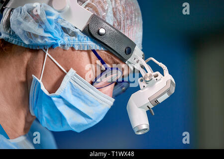 Close up portrait of female surgeon médecin portant chapeau et masque de protection lors de l'opération. Les soins de santé, l'éducation médicale, chirurgie concept. Banque D'Images